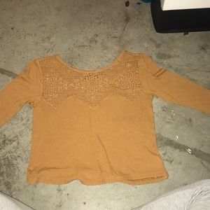 A tan crop top with lace on top